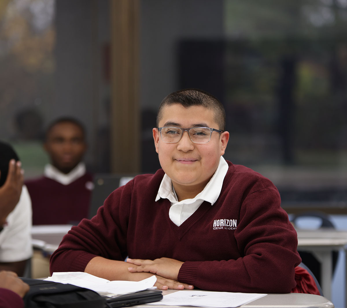 Student working on a notebook in a classroom.