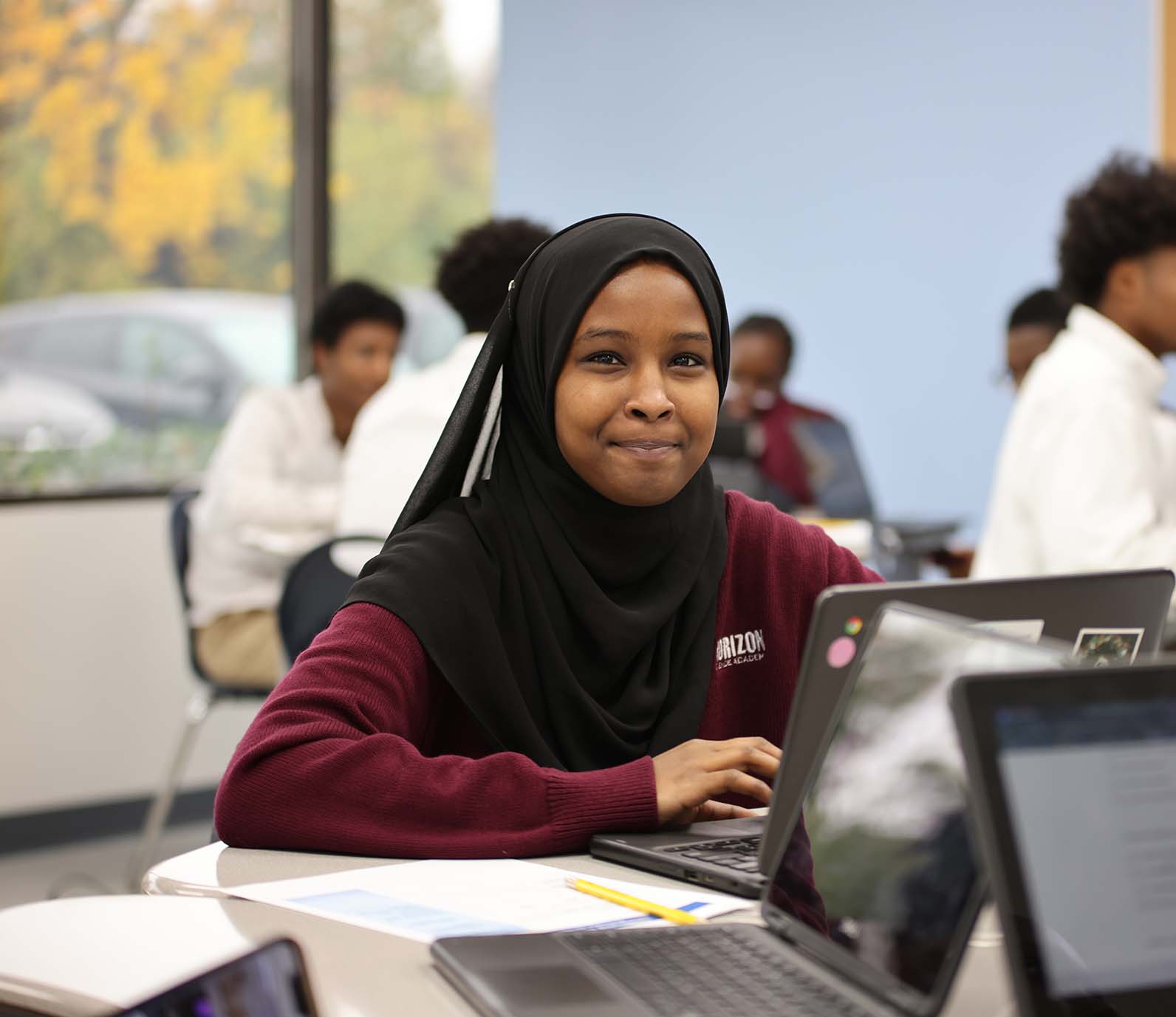 Horizon Science Academy student wearing headphones uses a laptop in class